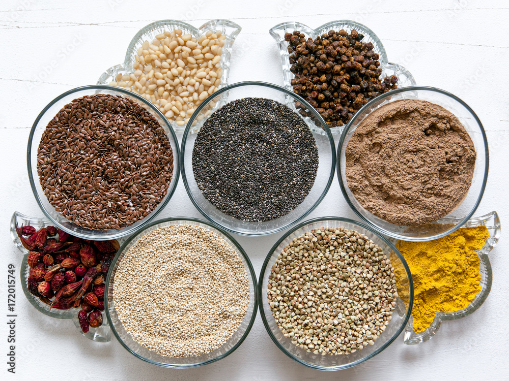 Superfoods in glassware on white background. Bright colorful flat lay of healthy food products. Superfoods in glassware on white background. Bright colorful flat lay of healthy food products.