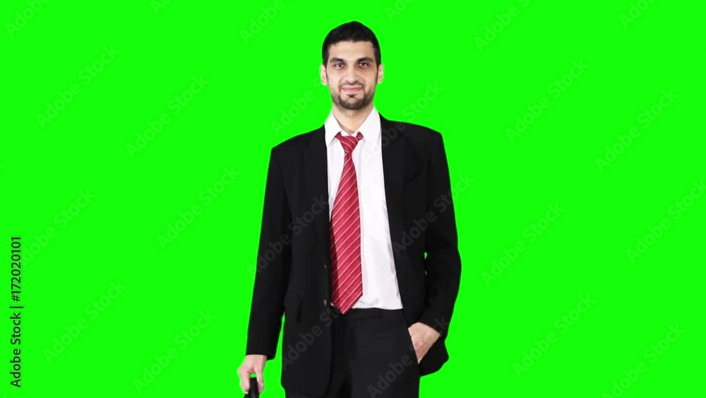 Young handsome caucasian businessman standing and smiling in the studio while wearing business suit and holding a briefcase in front of green screen background Young handsome caucasian businessman standing and smiling in the studio while wearing business suit and holding a briefcase in front of green screen background