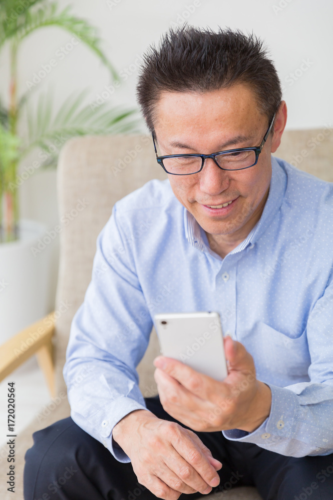 スマホを見るミドル男性 スマホを見るミドル男性