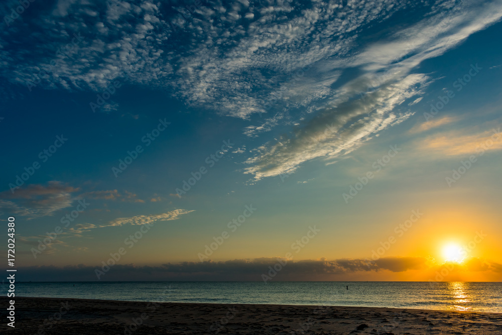 Fototapeta premium morning sun and blue sky over the ocean on a calm morning