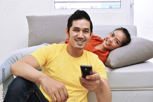 Young asian loving couple relaxing and watching television