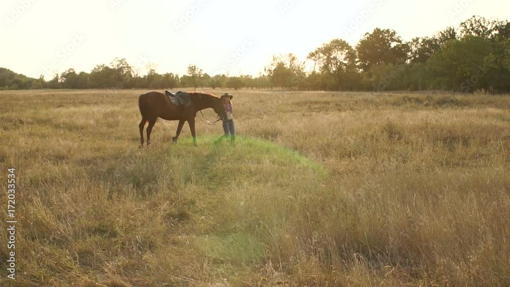 Teen girl walking with a horse in a field at sunset, slow motion. Teen girl walking with a horse in a field at sunset, slow motion.