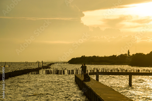 sihouette people at concrete walkway on vacation for seaview in sunset with soft sunlight