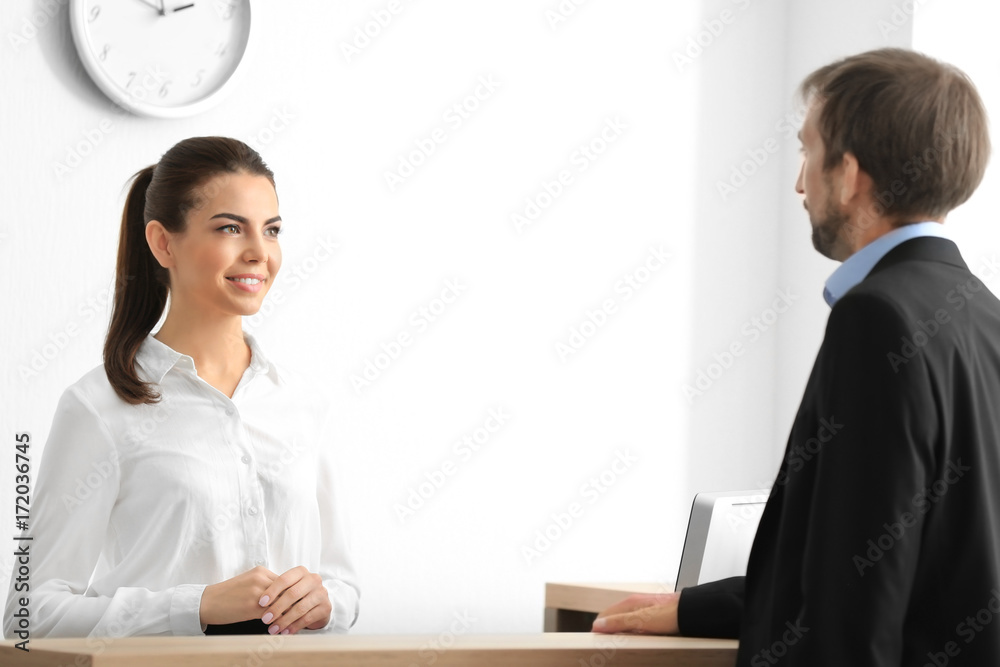 Obraz premium Young female receptionist meeting client in office