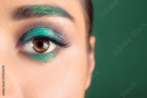 Young woman with creative makeup on color background, close up