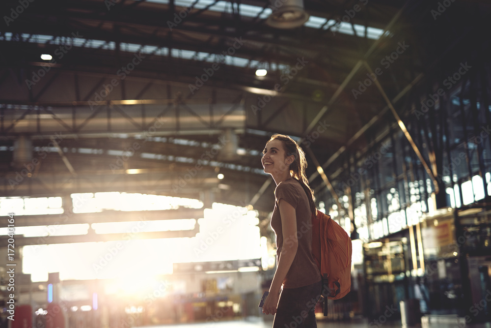 Φωτογραφία young woman in the hall of the airport terminal with small backpack as a hand luggage