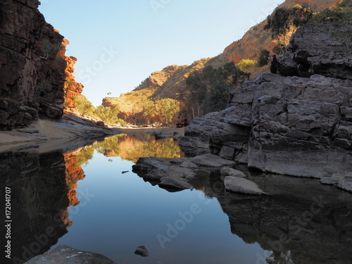 Reflections in the dark waters of Ormiston Gorge with red glowing cliffs in the evening sun, Northern Territory, Australia 2017