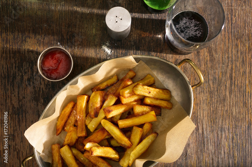 Pan of fries with ketchup and glass of dark beer
