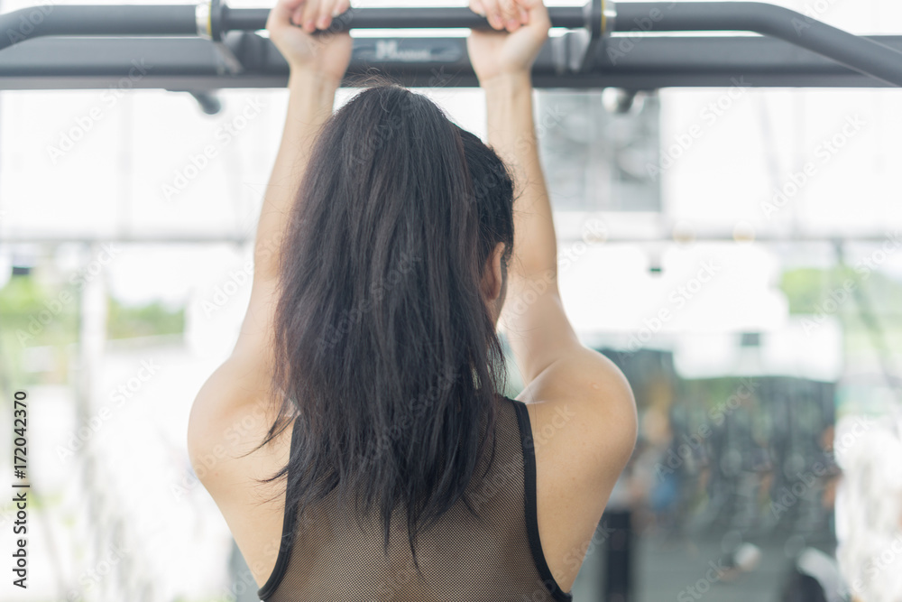 Fitness woman in training showing exercises with exercise-machine in gym Fitness woman in training showing exercises with exercise-machine in gym