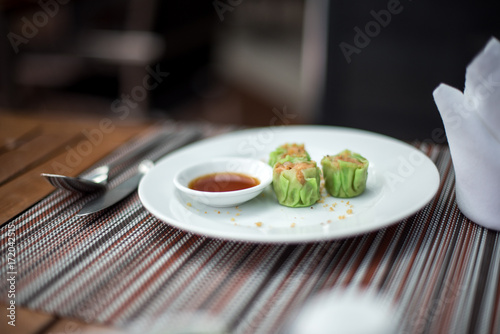 Dim sum on white plate with sour sauce photo