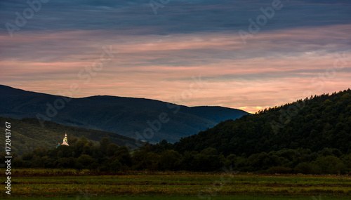 church dome over the forest in valley at dawn. mysterious countryside autumn landscape