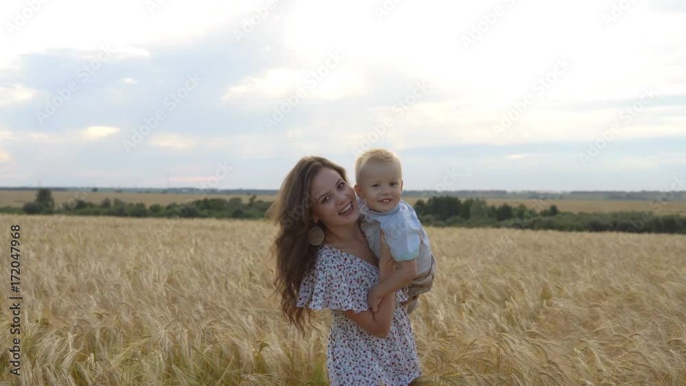 Mother with her son walking through a wheat field Mother with her son walking through a wheat field