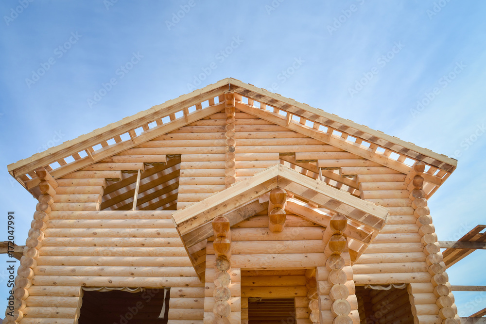 Structure of a new wooden house under construction on blue sky background