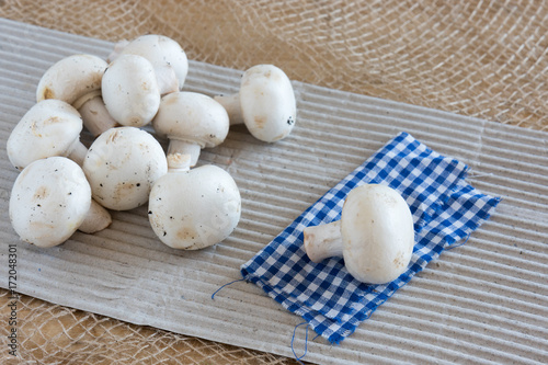 White mushrooms champignon on a table. Healthy vegetarian food.