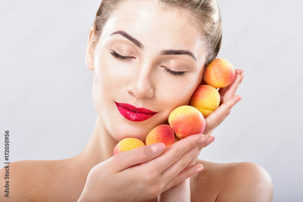 Beautiful woman holding a juicy apricots, peaches. Perfect skin. Fruit facial masks. Professional makeup. Beautiful woman holding a juicy apricots, peaches. Perfect skin. Fruit facial masks. Professional makeup.