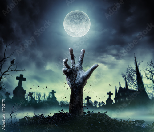 Fotografiet Zombie Hand Rising Out Of A Graveyard