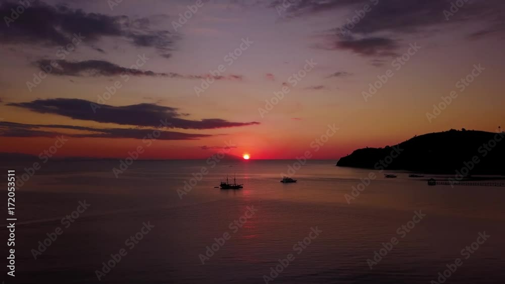 Beautiful aerial landscape of sunset over the sea with silhouette boats in Labuan Bajo at Flores Island an island located near Bali, Indonesia. Shot in 4k resolution Beautiful aerial landscape of sunset over the sea with silhouette boats in Labuan Bajo at Flores Island an island located near Bali, Indonesia. Shot in 4k resolution