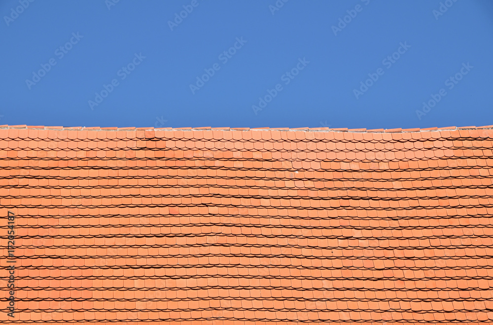Red brown ceramic roof tiles over blue sky