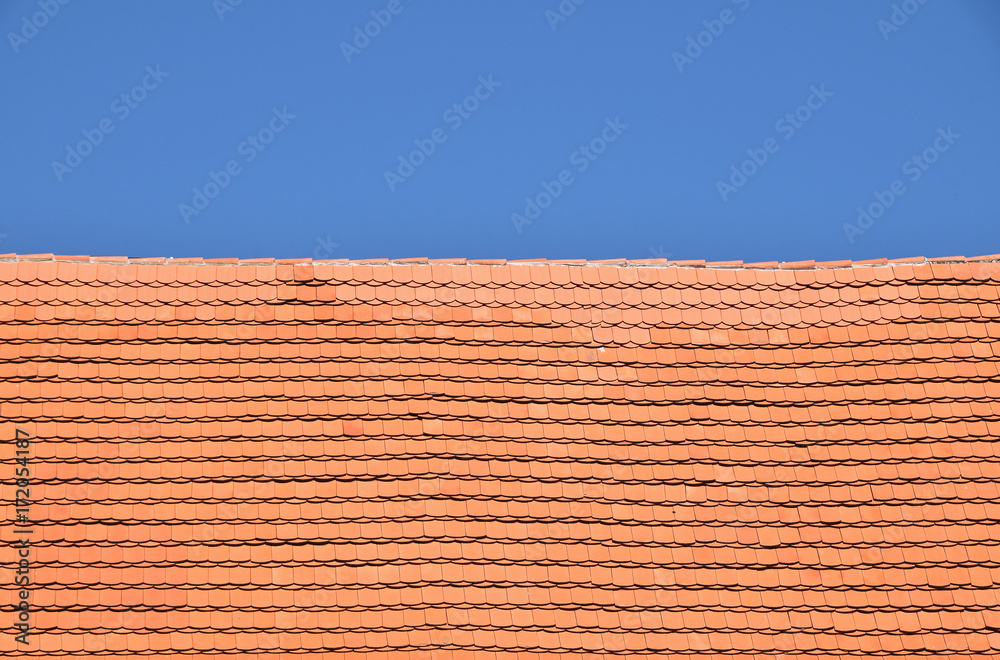 Red brown ceramic roof tiles over blue sky Red brown ceramic roof tiles over blue sky