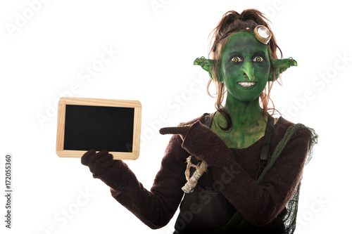 lustiger weiblicher goblin zeigt auf Tafel mit Textfreiraum