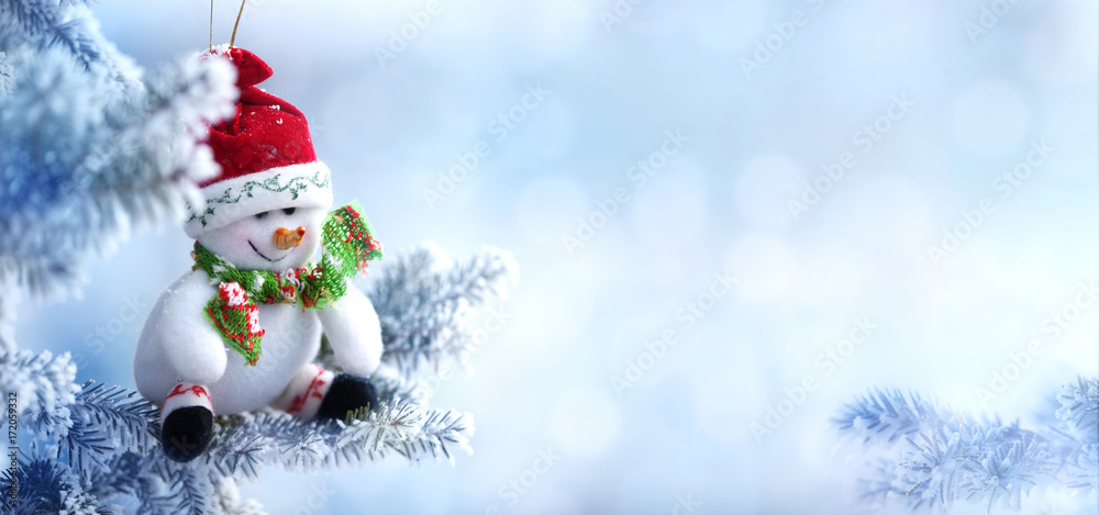 Christmas Snowman Hanging on a Snow Tree Branch
