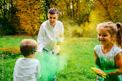 father doughet and son playing with holi paints