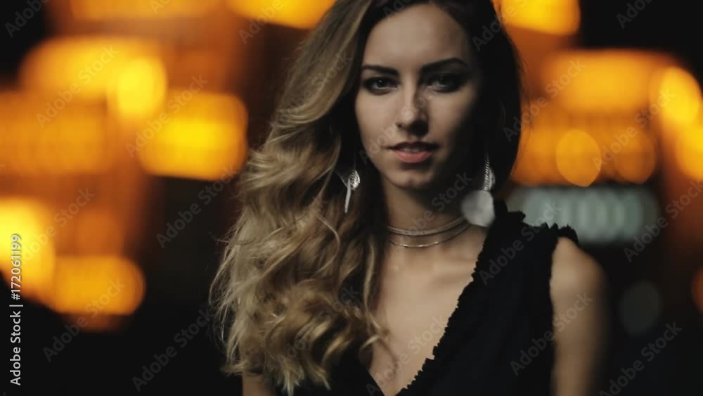 Fashion model with beautiful hair walking in a night city street Fashion model with beautiful hair walking in a night city street