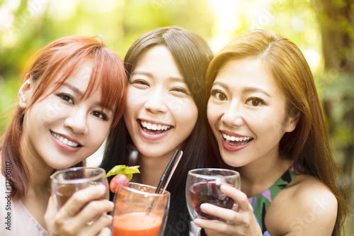 Three happy friends talking and drinking in restaurant.