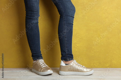 Female feet in golden sneakers