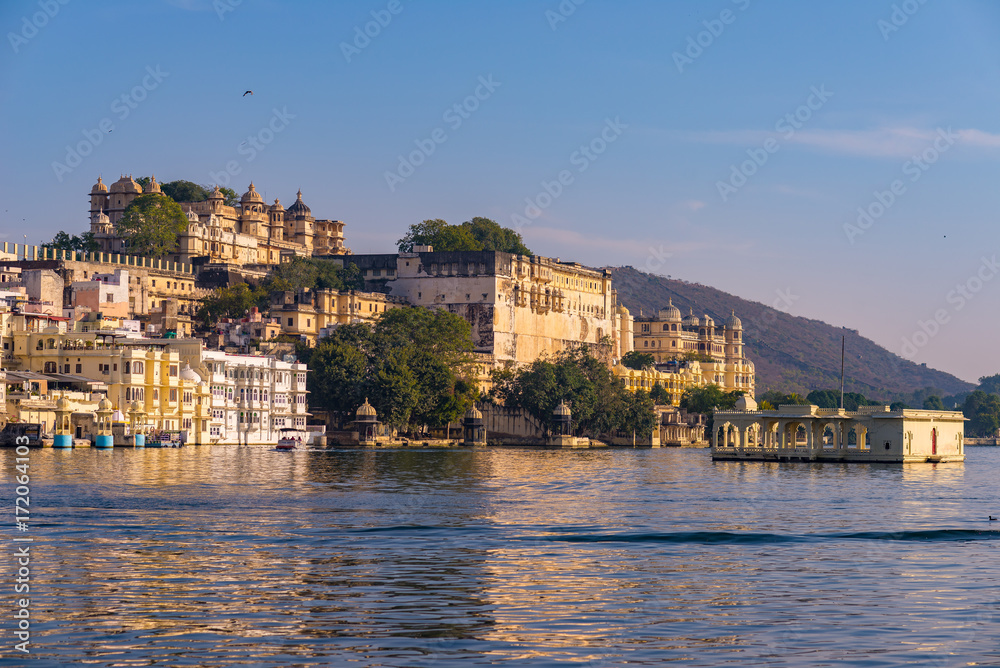 Udaipur cityscape with colorful sky at sunset. The majestic city palace on Lake Pichola, travel destination in Rajasthan, India