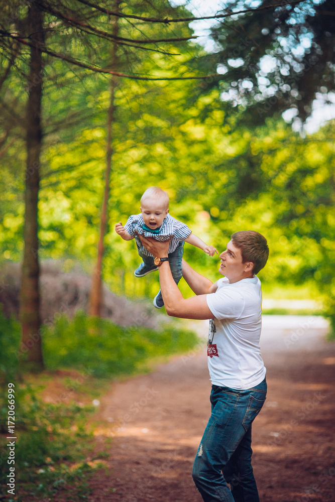 father walks with the little son in the park, the kid takes the first steps father walks with the little son in the park, the kid takes the first steps