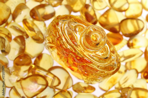   An antique bottle close-up against a background of yellow amber stones.
