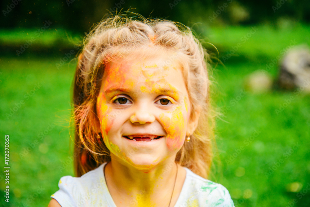 Portrait of a cute girl painted in the colors of Holi festival. Portrait of a cute girl painted in the colors of Holi festival.