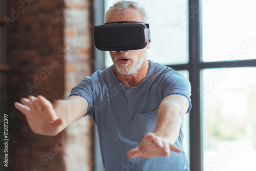 Excited aged man testing VR glasses