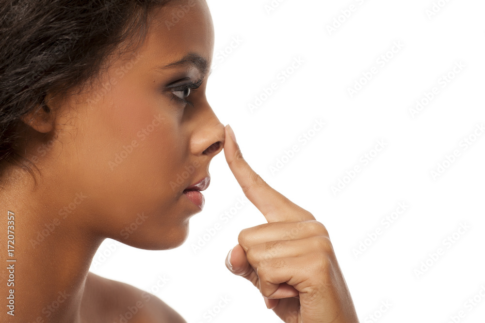 Young dark skinned woman touching her nose Young dark skinned woman touching her nose