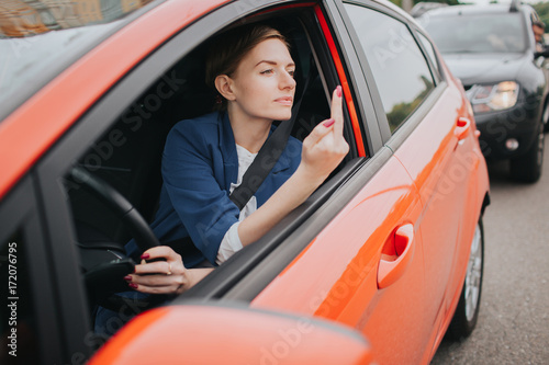 A woman feels stress on the road. Shows the fact in the window. Big Traffic jams. Business woman is late for work