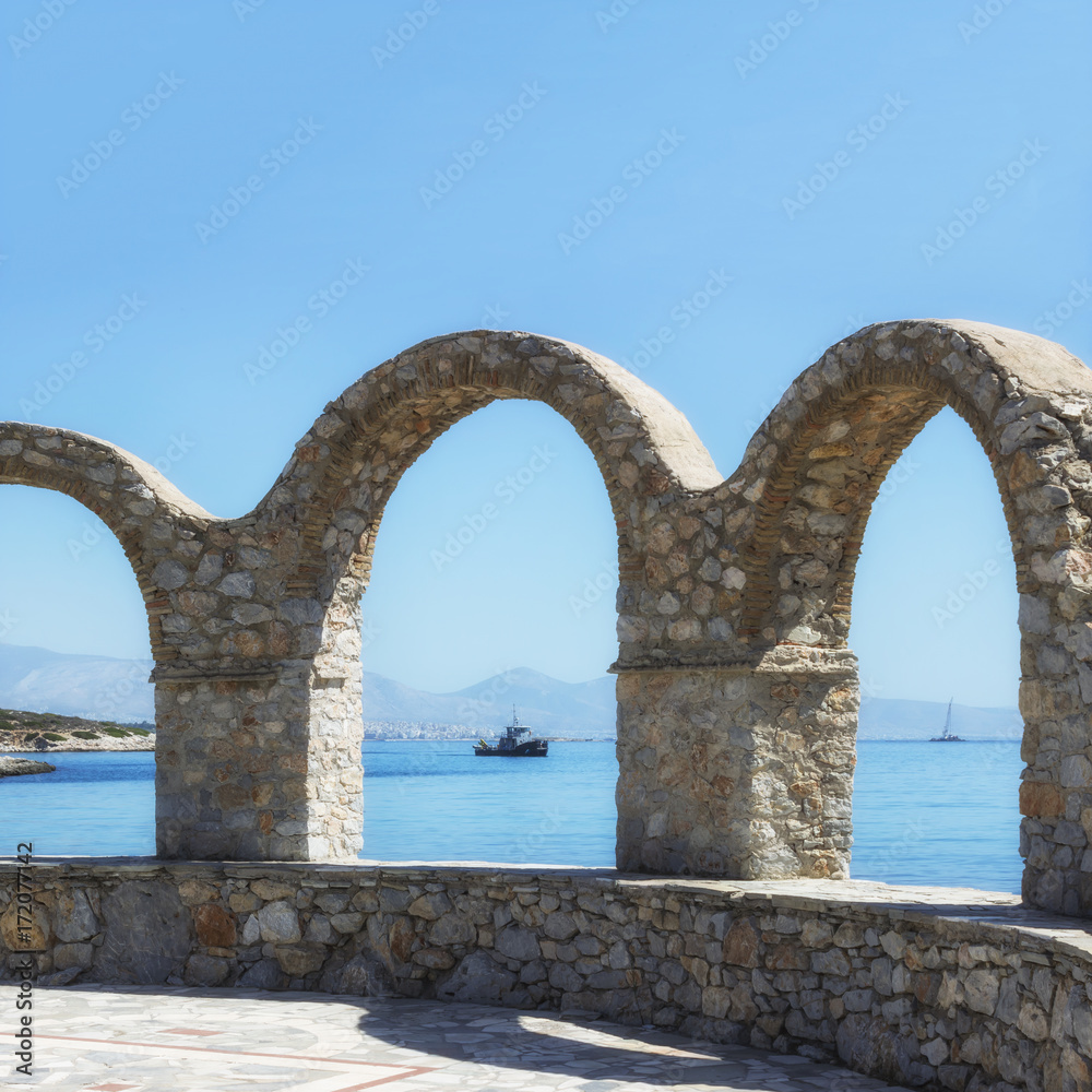 Terrace with stone arch. Scenic view of the sea, mountains and ships. Greece. Terrace with stone arch. Scenic view of the sea, mountains and ships. Greece.