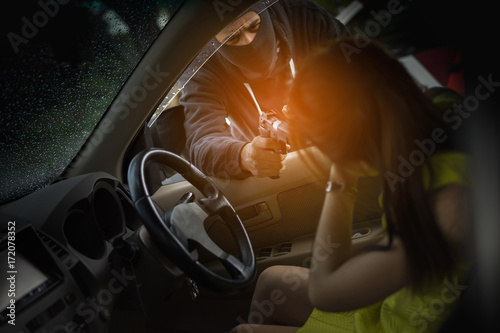 Foto Bandit man holding handgun to hijack hostage woman shocked in car violence conce