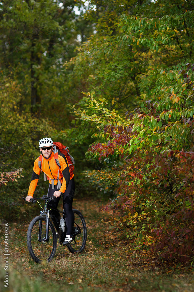 back view of a man with a bicycle and red backpack against the blue sky. cyclist rides a bicycle. back view of a man with a bicycle and red backpack against the blue sky. cyclist rides a bicycle.