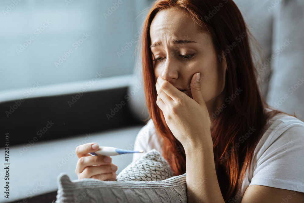Unhappy ill woman having a body temperature Unhappy ill woman having a body temperature