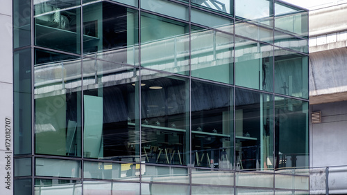 View from outside of office glass window facade. New modern style office room architecture in city with daylight.