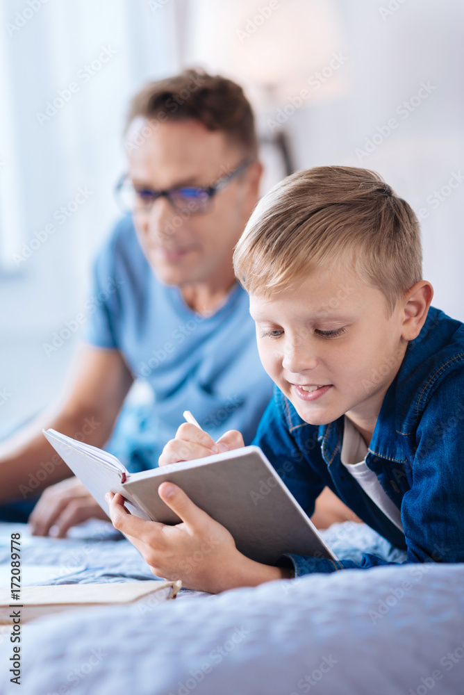 Charming little boy writing in his diary Charming little boy writing in his diary