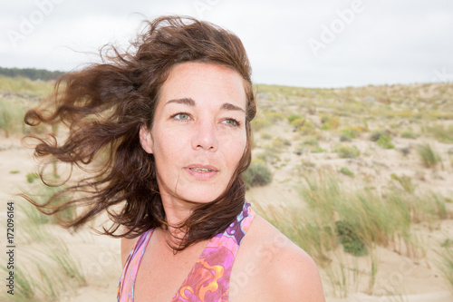 Portrait young woman smiling girl on beach wind in hair , summer holiday