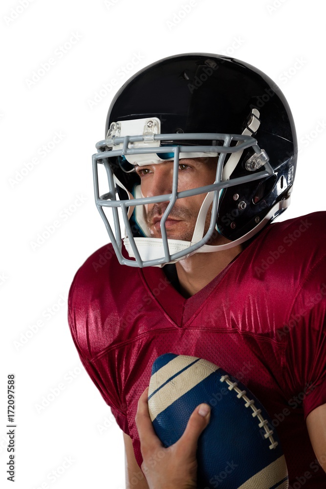 American football player wearing helmet holding ball