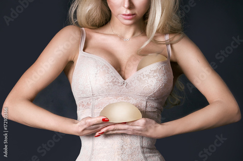 Silicone implants on hand and natural breast photo