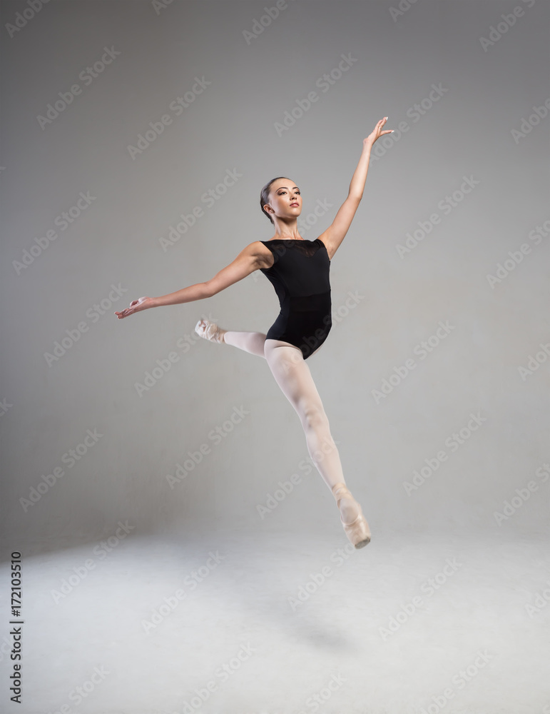 Elegant ballerina in black tights floating in the air Elegant ballerina in black tights floating in the air