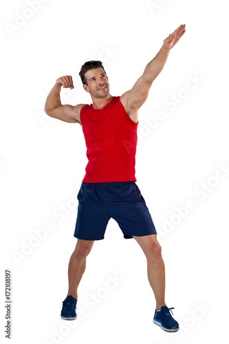 Full length of sports player flexing muscles with hand raised © WavebreakMediaMicro