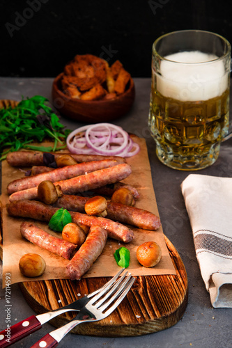 Grilled sausages with glass of beer on black table. Oktoberfest.