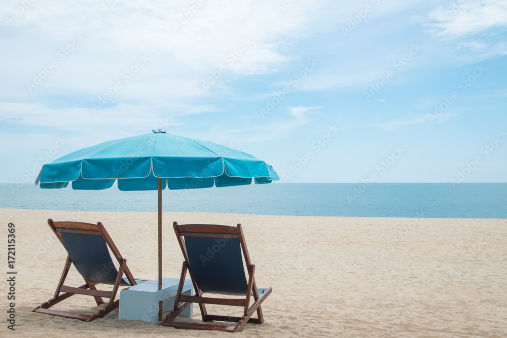 Beach chairs and blue umbrella on beautiful sand beach with cloudy and blue sky Beach chairs and blue umbrella on beautiful sand beach with cloudy and blue sky