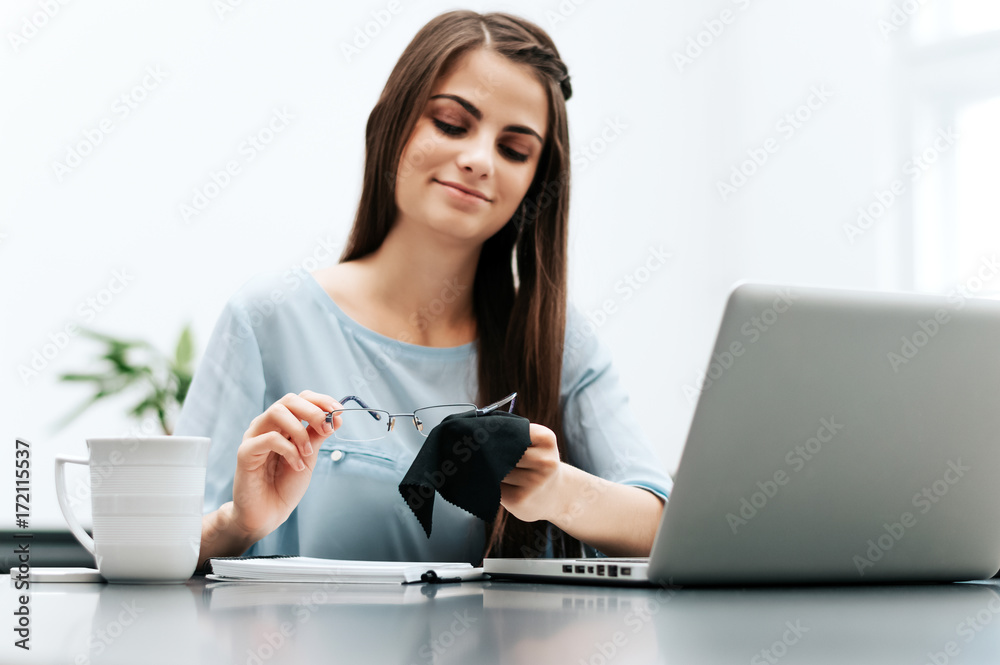 Portrait of a businesswoman cleaning her glasses in the office. Portrait of a businesswoman cleaning her glasses in the office.